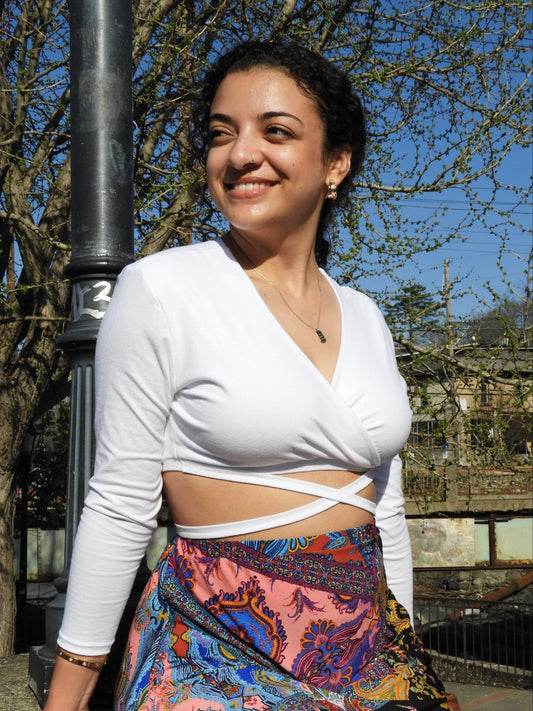 White long-sleeve micro wrap top. Ties wrap around the body like an "x".