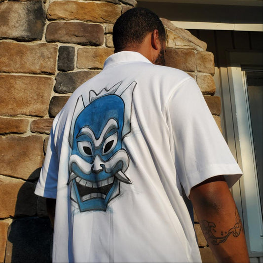White polo with painted Blue spirit mask on the back of the shirt.